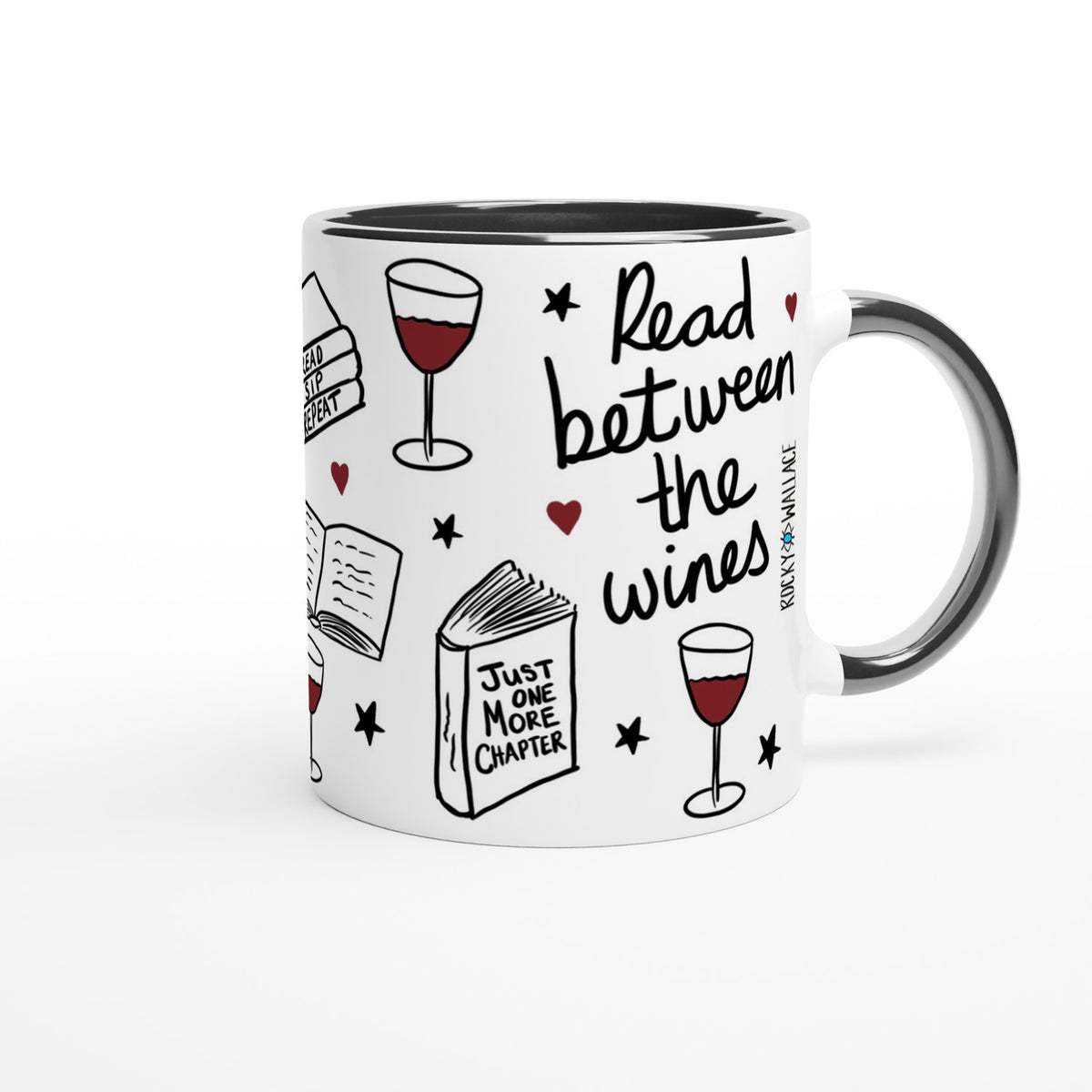 A white ceramic coffee mug with a black handle and interior, decorated with illustrations of books, wine glasses, stars, and hearts, alongside the text 'Read between the wines' and 'Just one more chapter'.